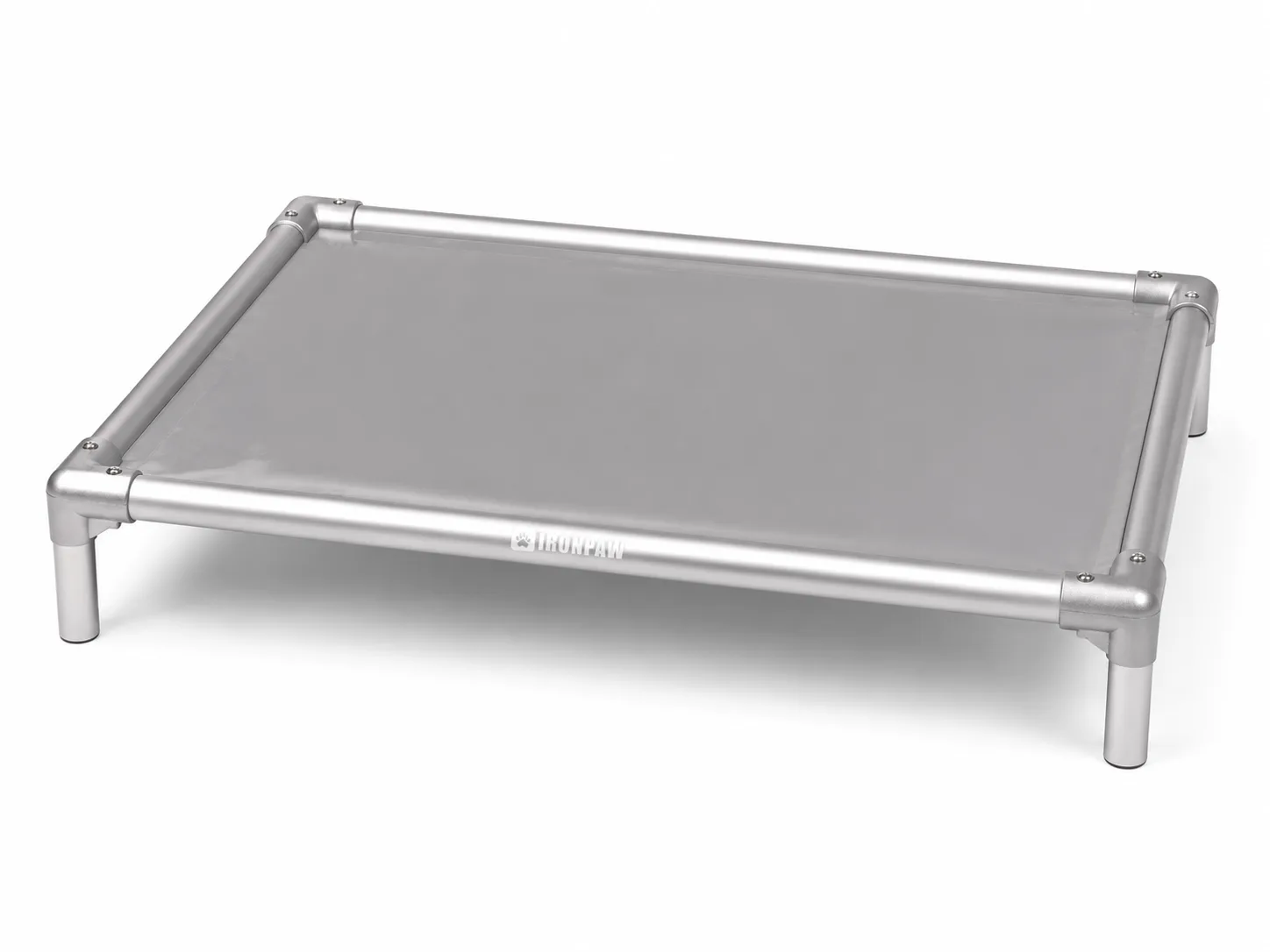 Commercial studio product photo of the Mist Elevated Dog Bed with glossy neutral grey PVC fabric, brushed silver aluminium frame, rounded corner connectors, bare tube legs, visible hex screws, and centred pale IronPaw engraving on the front rail.